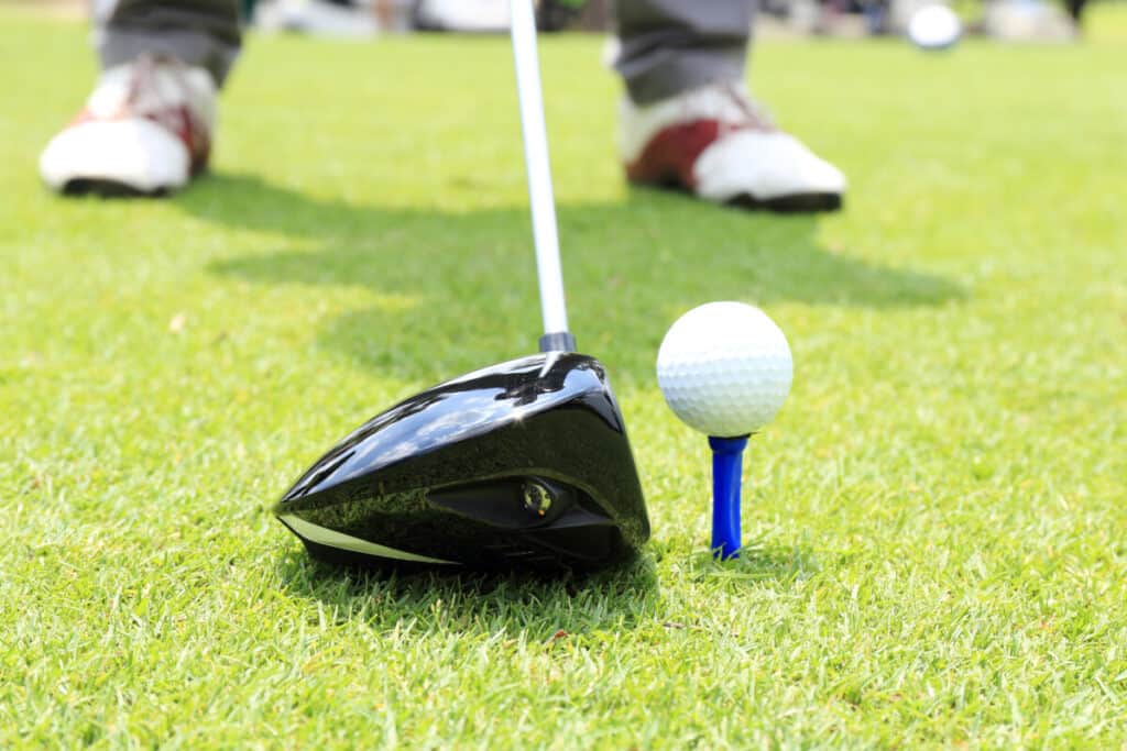 Close up of amateur golfer placing his driver behind the ball.