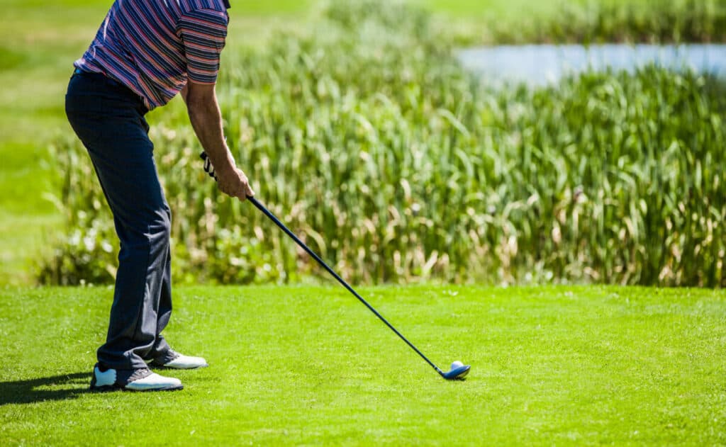 Amateur male golfer hitting hybrid off the tee