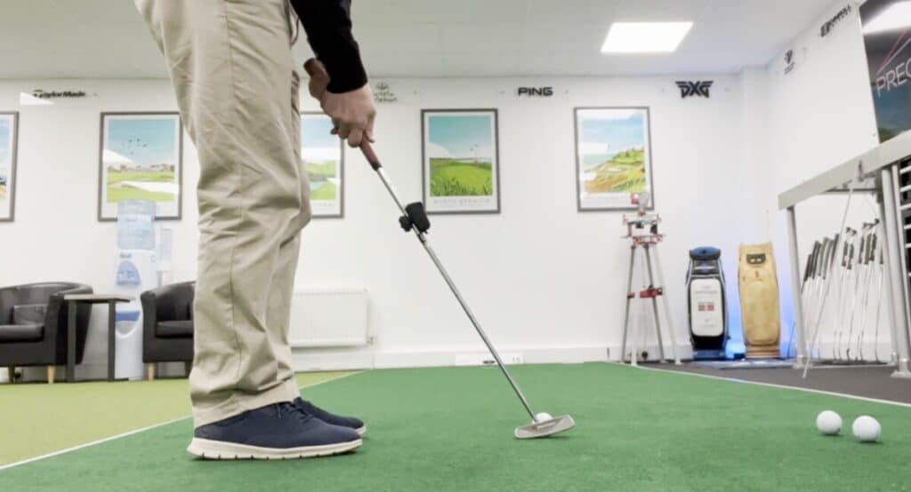 Golfer setting up to putt at a putting lesson and fitting